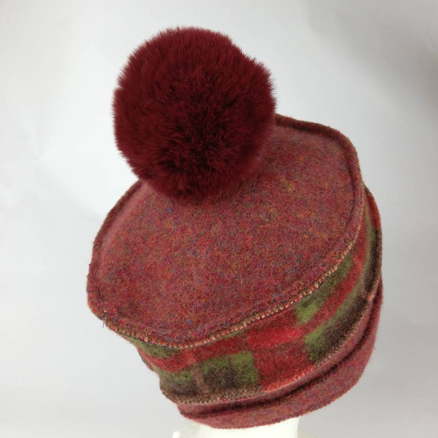 Bordeaux-und rot\grün kariert farbene Schnittkantenmütze mit bordeauxfarbener Bommel aus Kunstfell